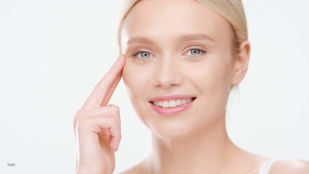 Female touching her eye with one finger 